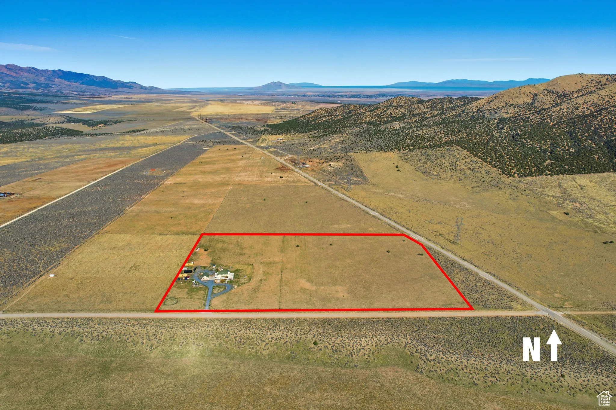 Aerial view of property parcel outlined and a mountainous background, north.