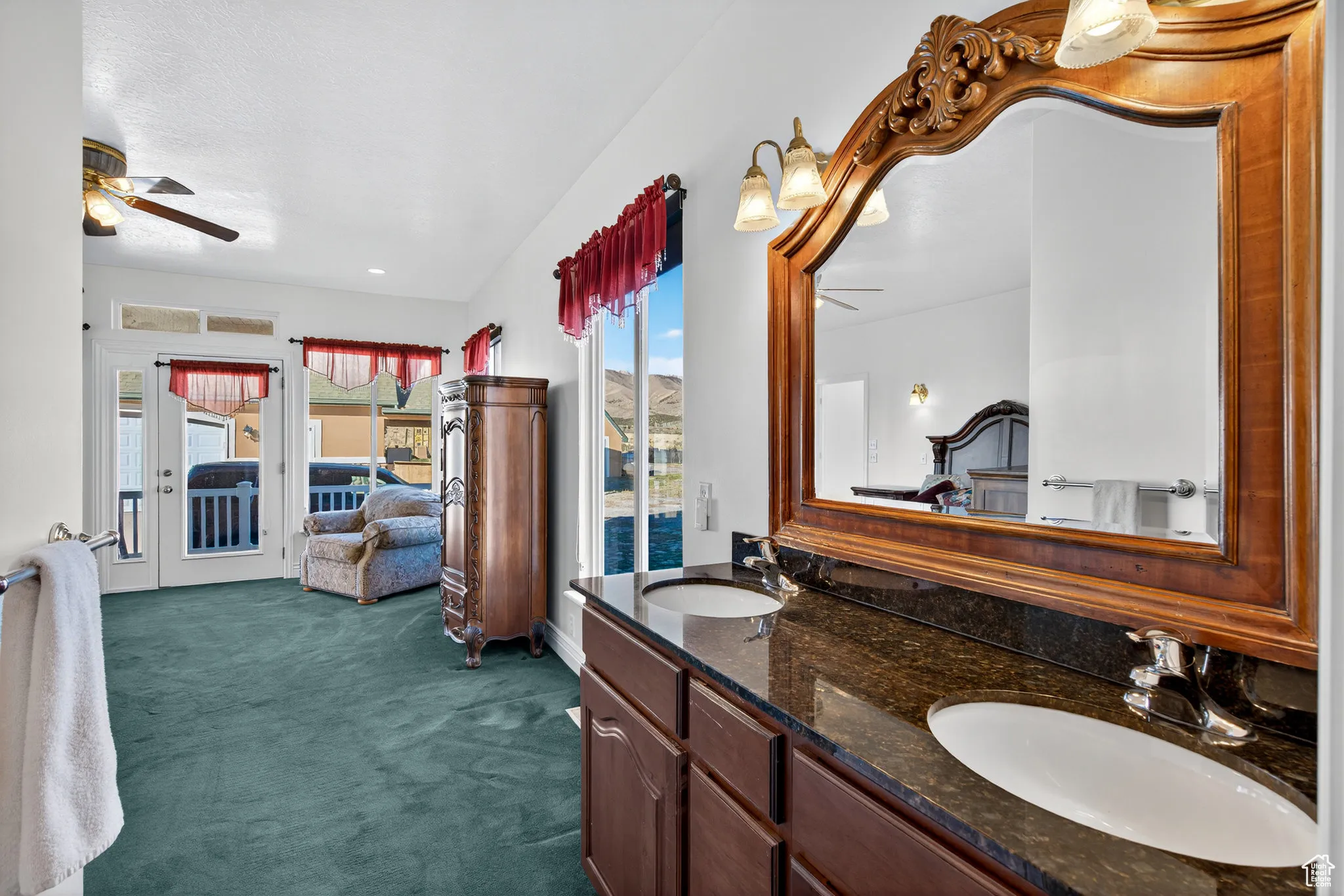 Primary bedroom ensuite bathroom featuring double vanity, dark carpet, and large windows.