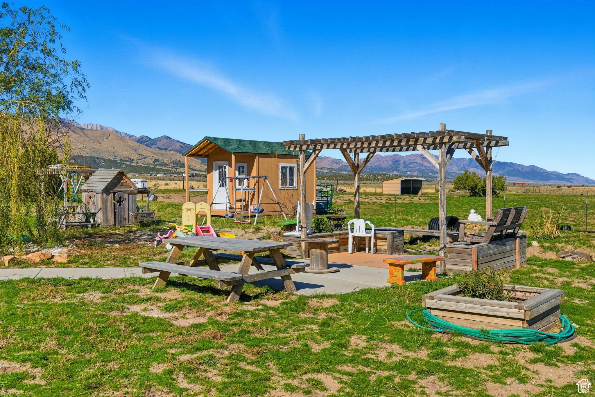 View of seating area with a pergola, a patio area, a shed, a mountain view, and a garden box.