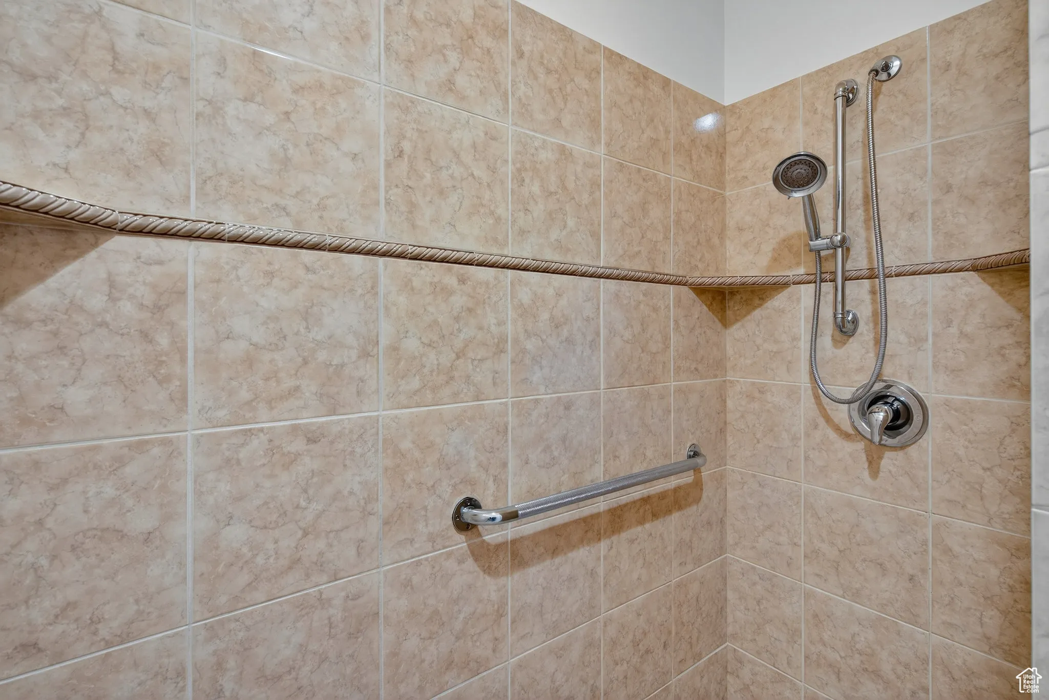 Primary bathroom walk in shower with grab bars.
