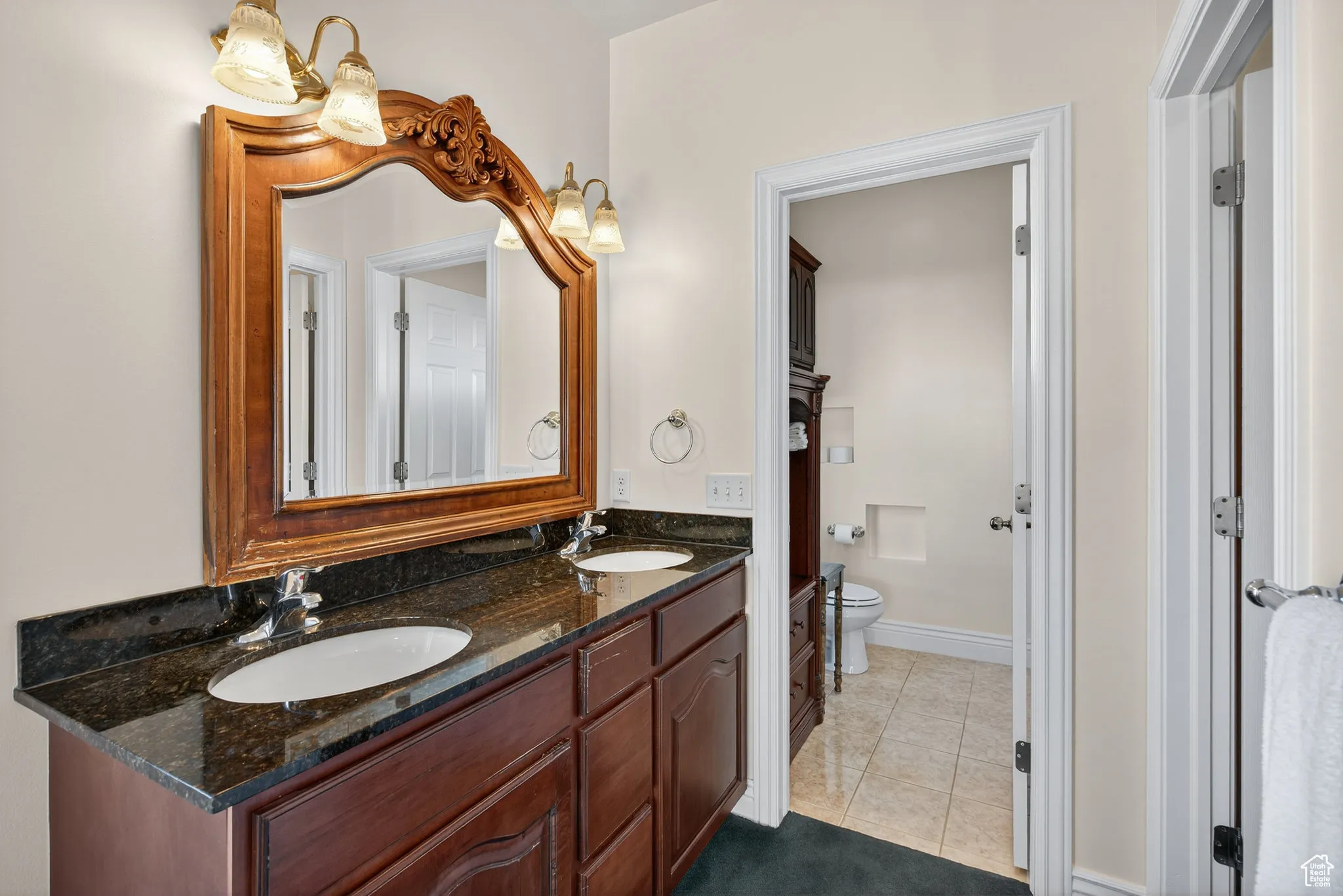 Primary bathroom with double vanity, walk in closet, water closet shower area.