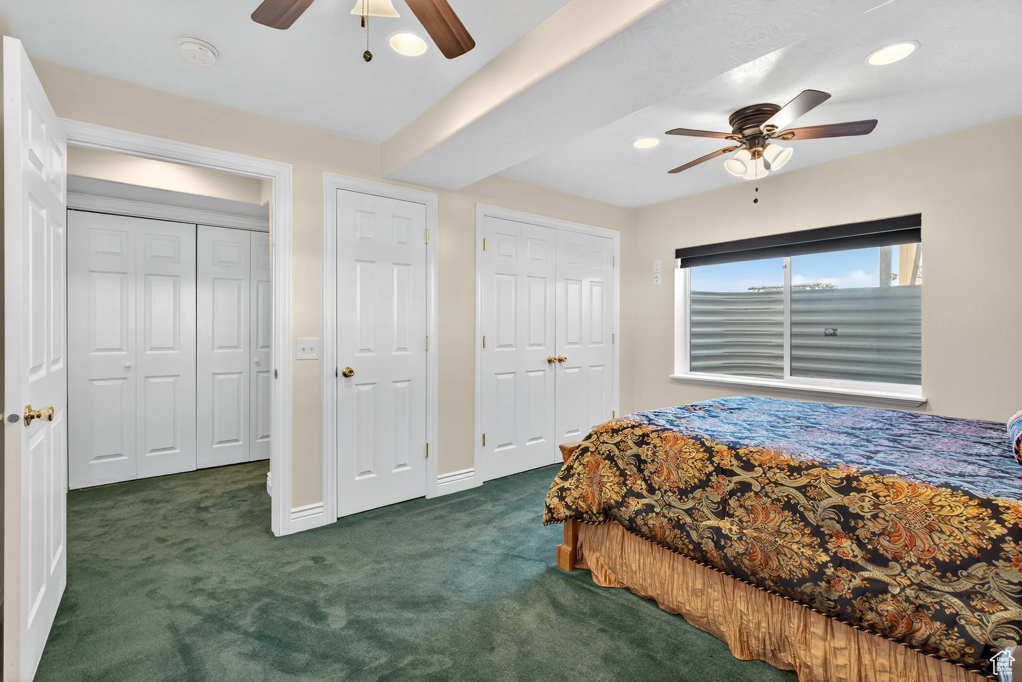 Basement bedroom featuring dark carpet, ceiling fan, two closets, and recessed lighting.
