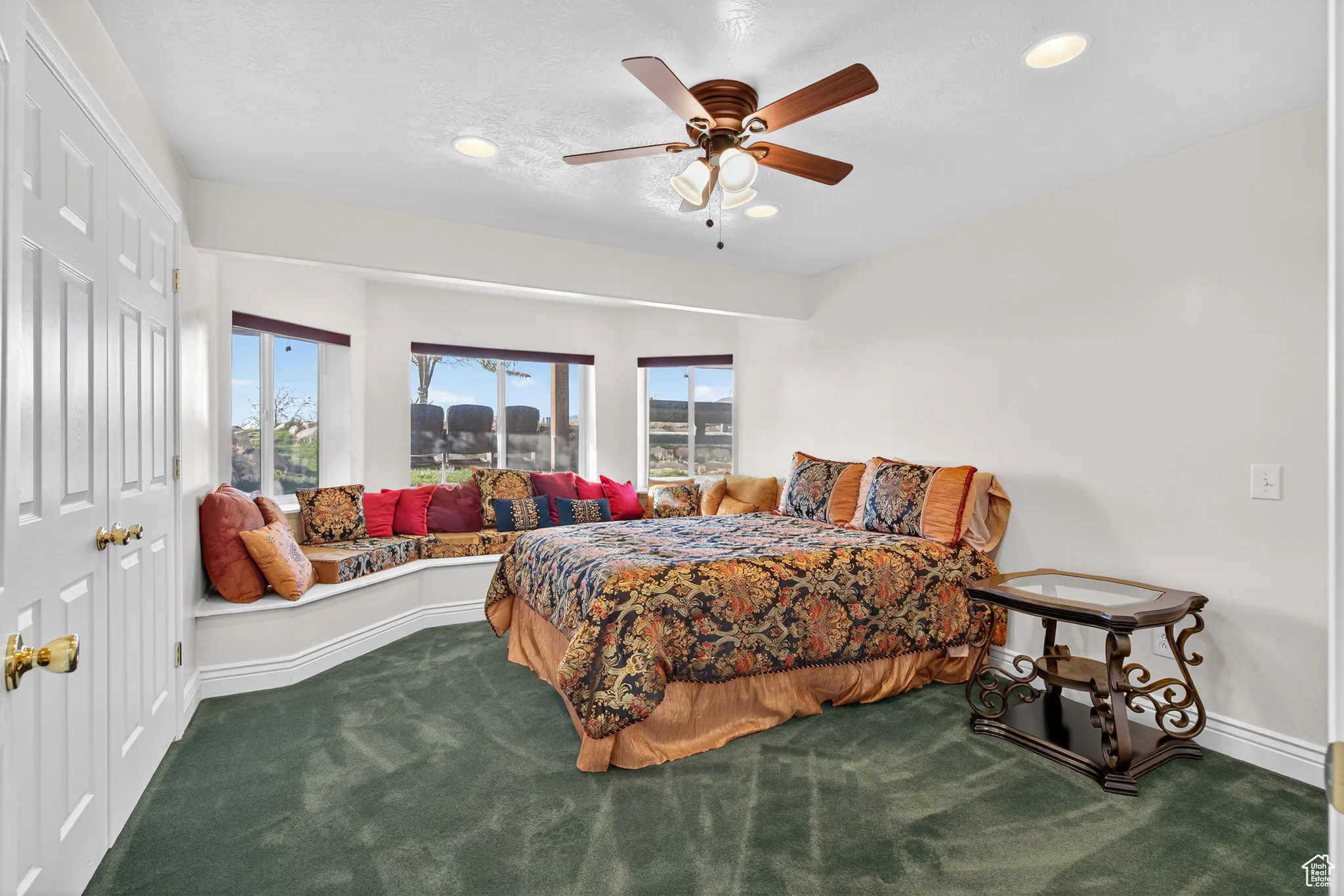 Basement bedroom featuring a closet, dark carpet, a ceiling fan, and recessed lighting.