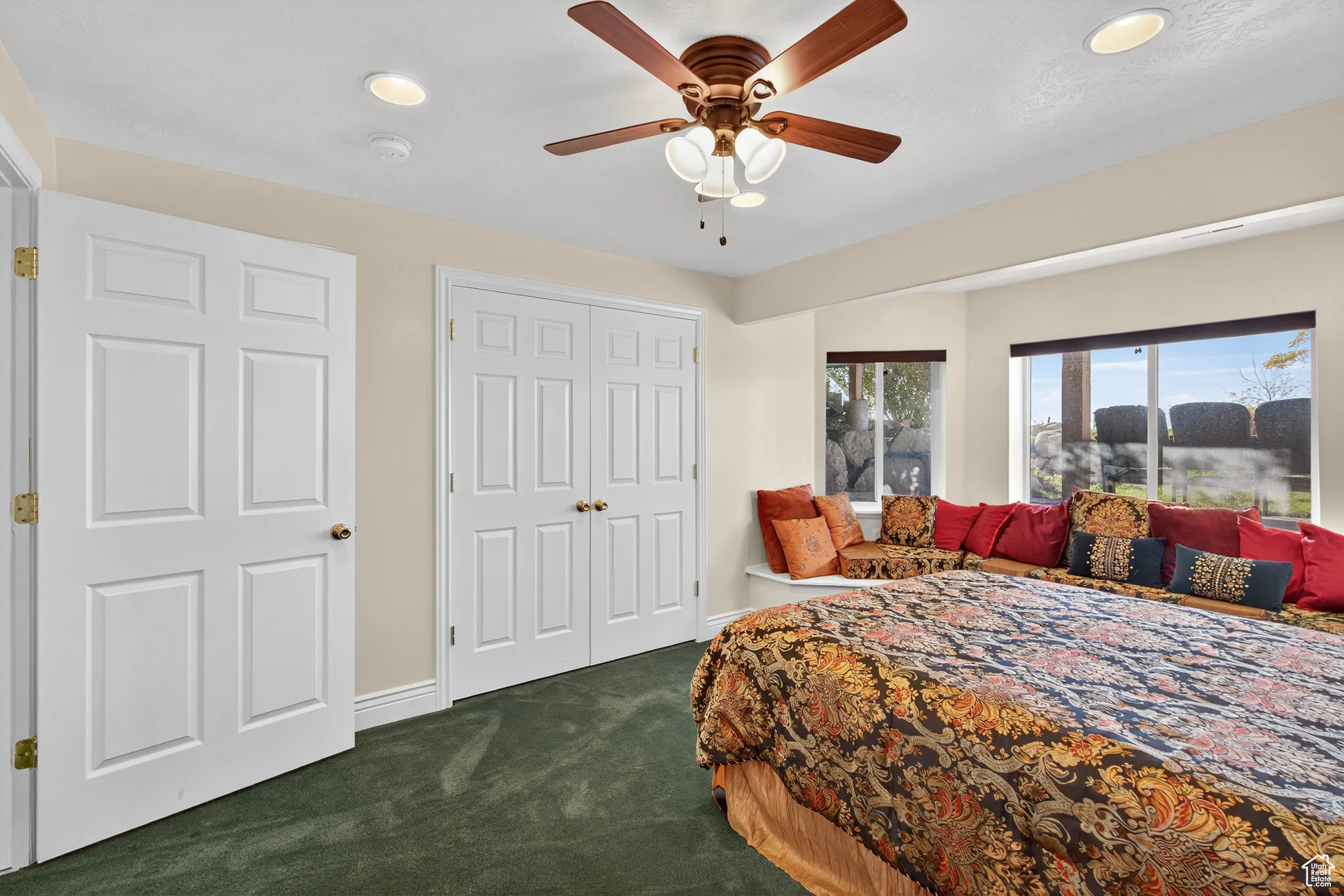Basement bedroom with dark carpet, recessed lighting, a closet, and a ceiling fan.