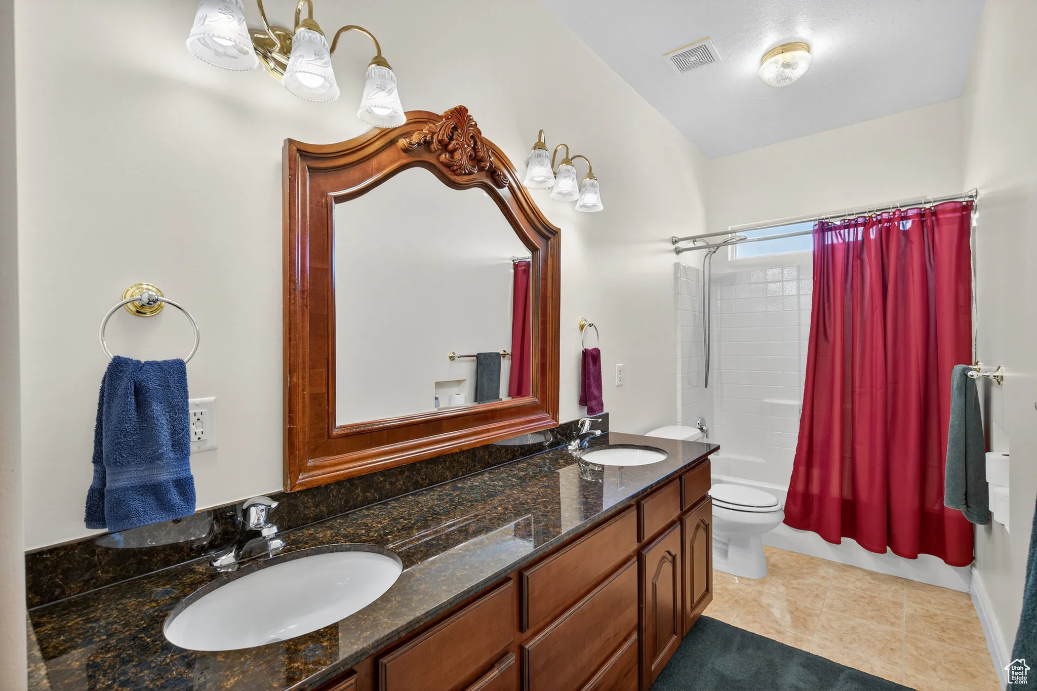 Second floor bathroom featuring shower / bath combo with shower curtain, double vanity, and light tile patterned floors.
