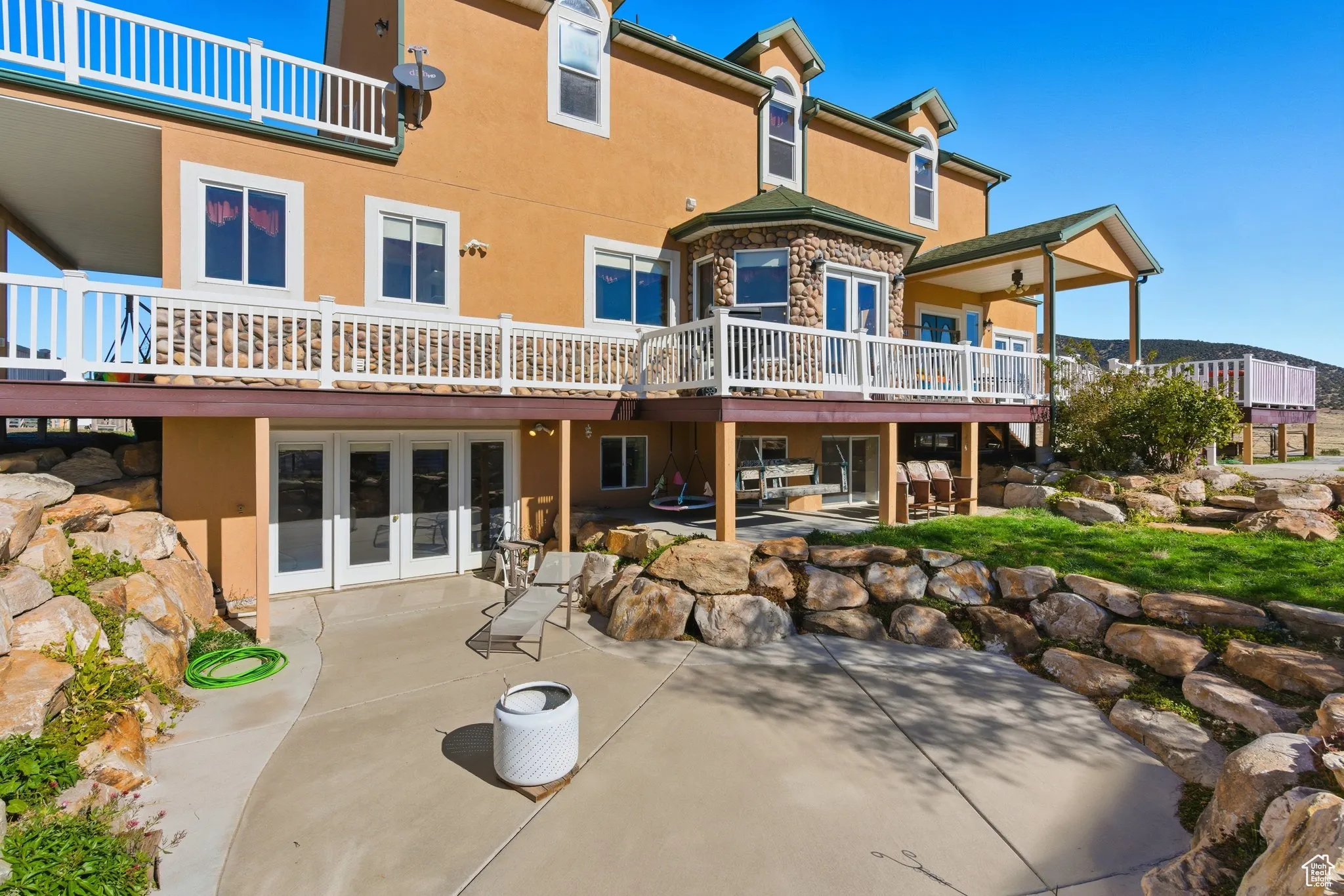 south side view of property with stucco siding, french doors and a patio.