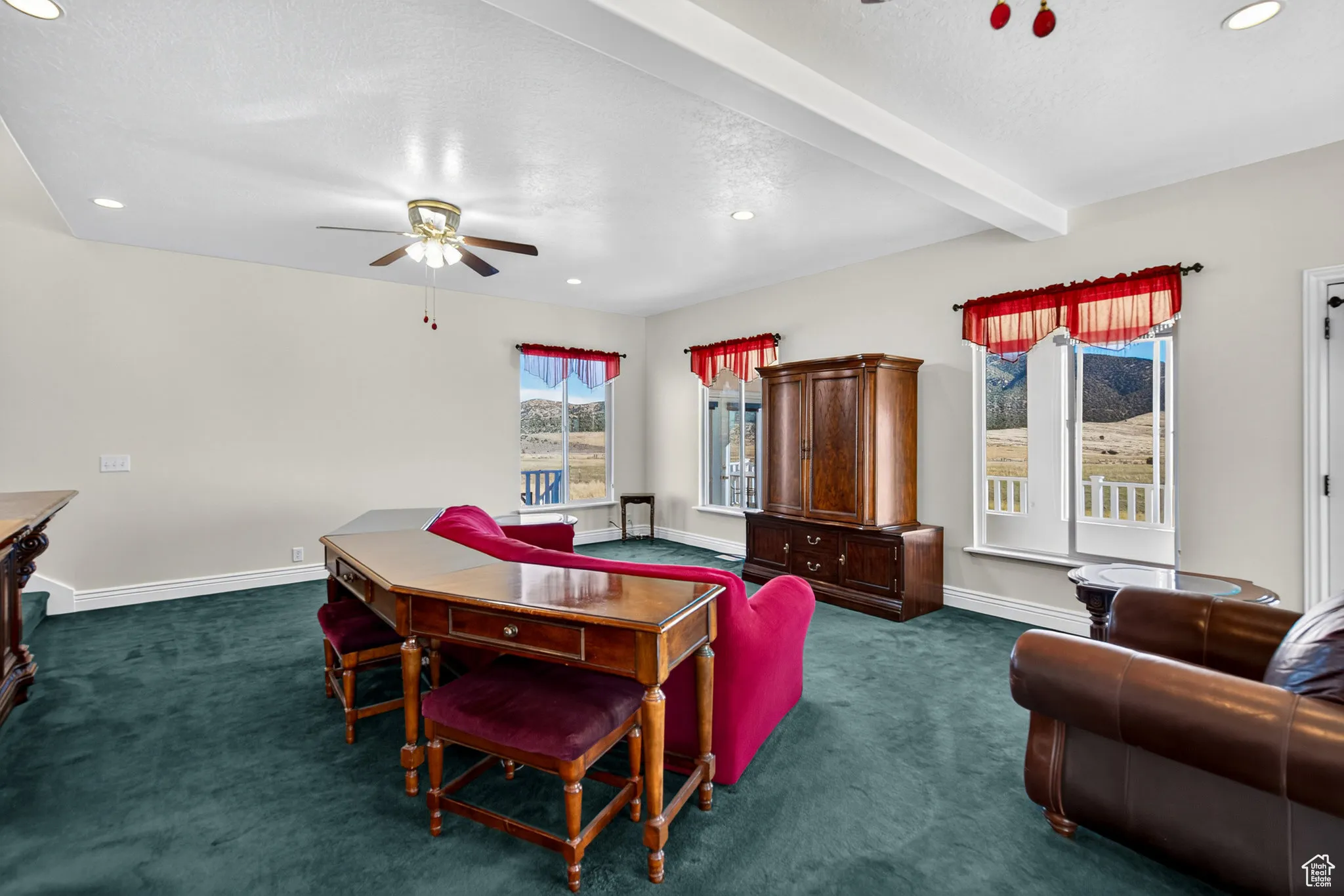 Living room with a ceiling fan, carpet, recessed lighting, beam ceiling.