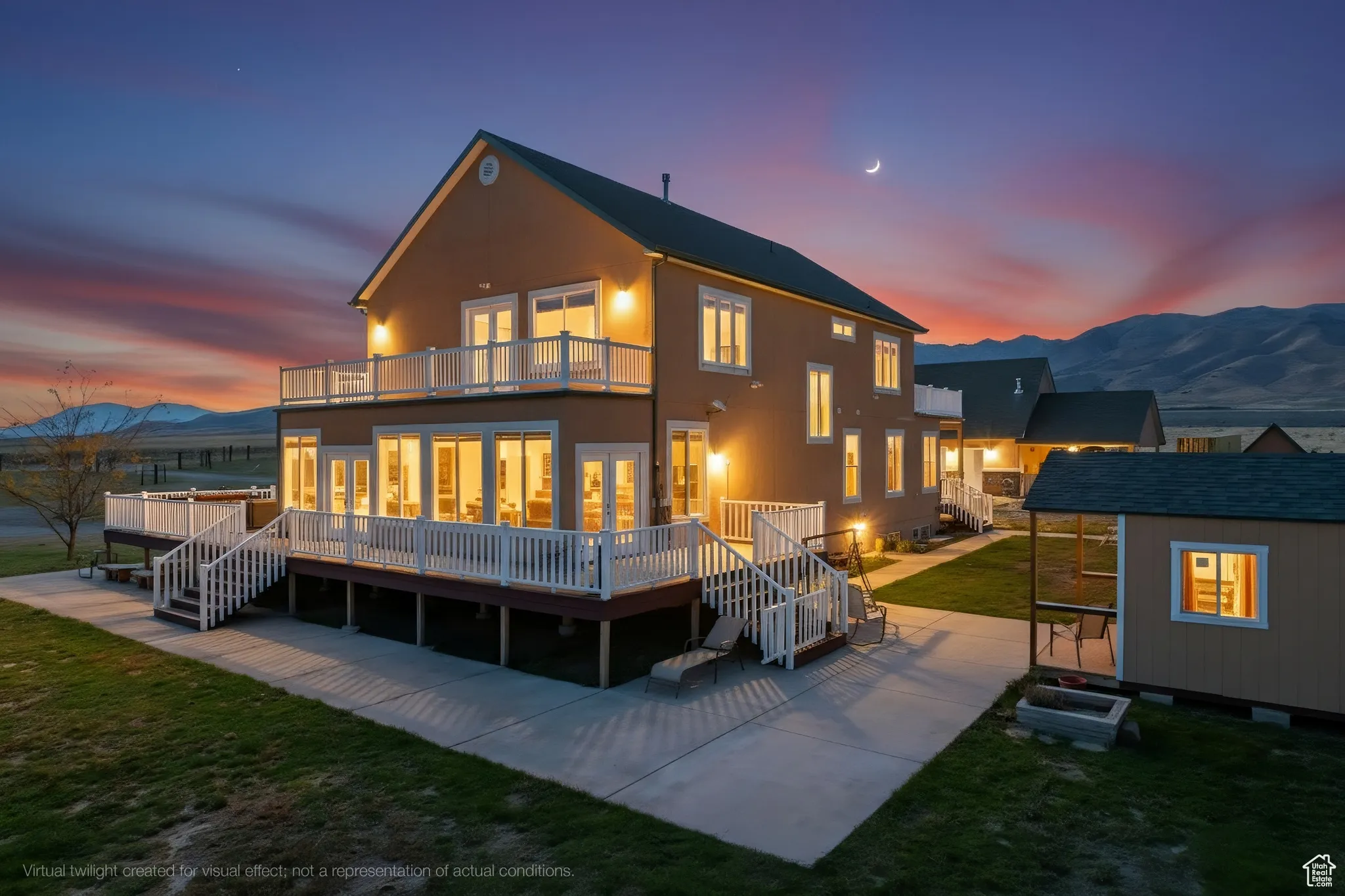 Rear view of house featuring a mountain view, a yard, an outbuilding.