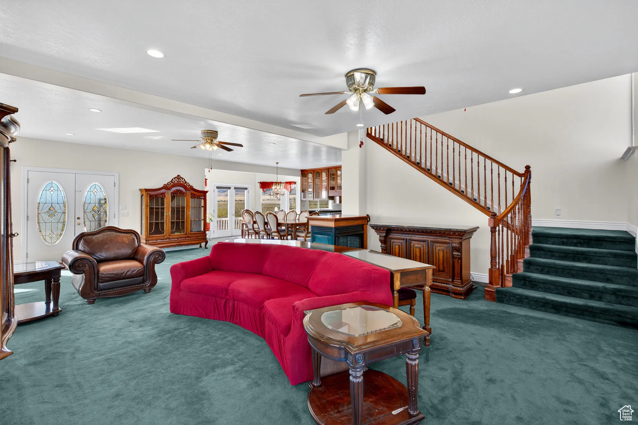 Living area with dark carpet, stairway, recessed lighting, and french doors.