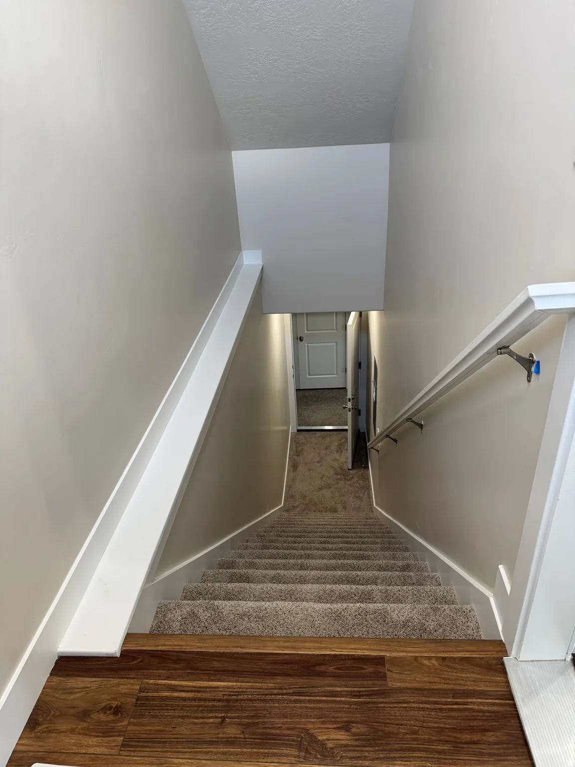 Staircase featuring carpet floors and a textured ceiling
