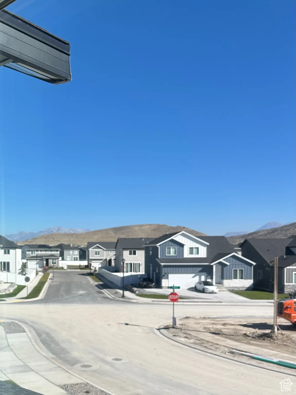 View of asphalt road with sidewalks, curbs, traffic signs, and a residential view