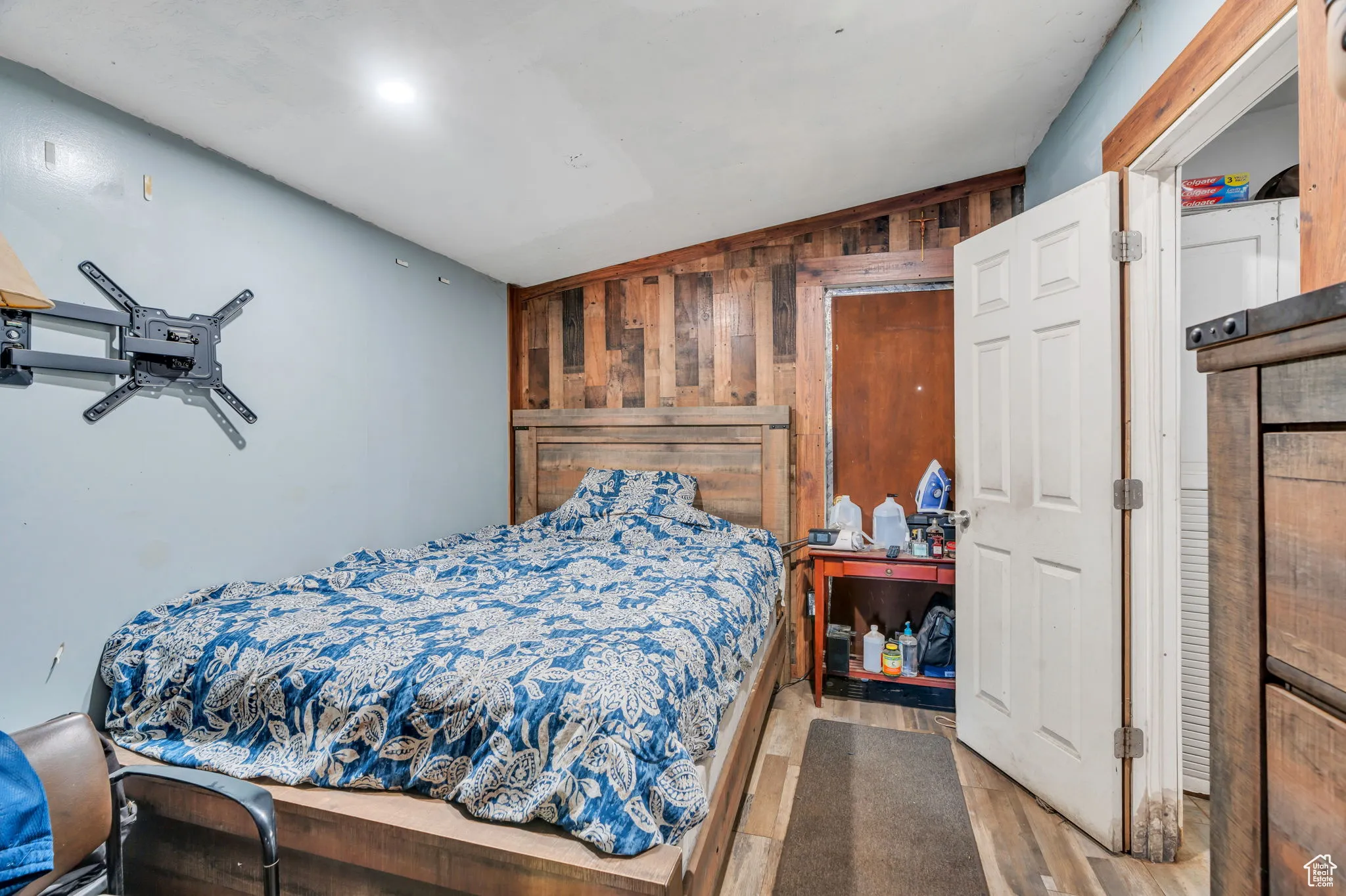 Bedroom with wooden walls, lofted ceiling, and wood finished floors