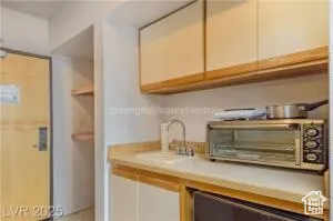 Kitchen with light countertops and white cabinetry