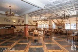 Dining room with a chandelier and inlaid floor details