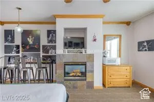 Bedroom featuring a tile fireplace and ornamental molding