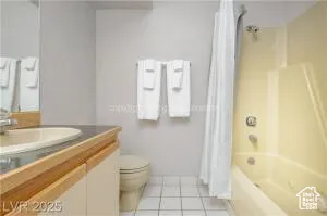 Full bath featuring vanity, shower / bath combination with curtain, and light tile patterned floors