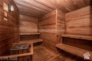 Relaxing sauna / steam room with wood ceiling, wooden walls, and wood finished floors