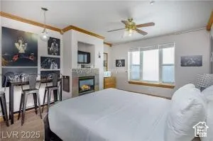 Bedroom with a lit fireplace and ornamental molding