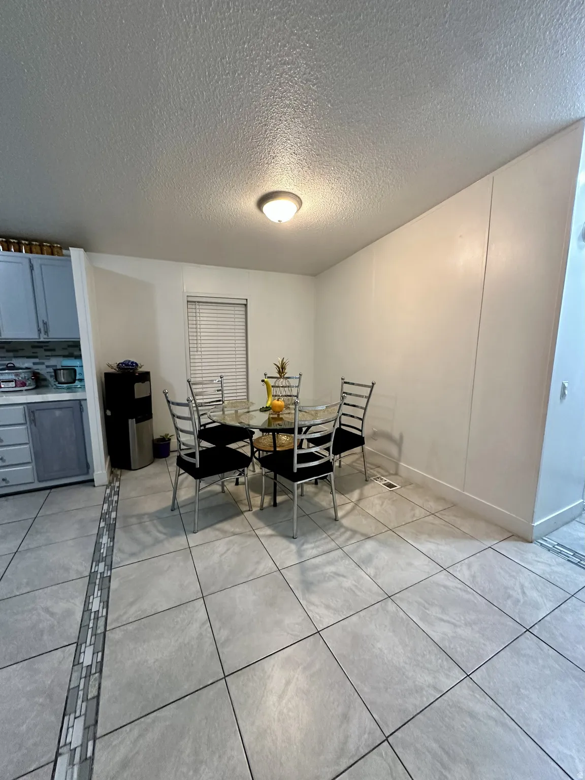 Dining room with light tile patterned floors and a textured ceiling