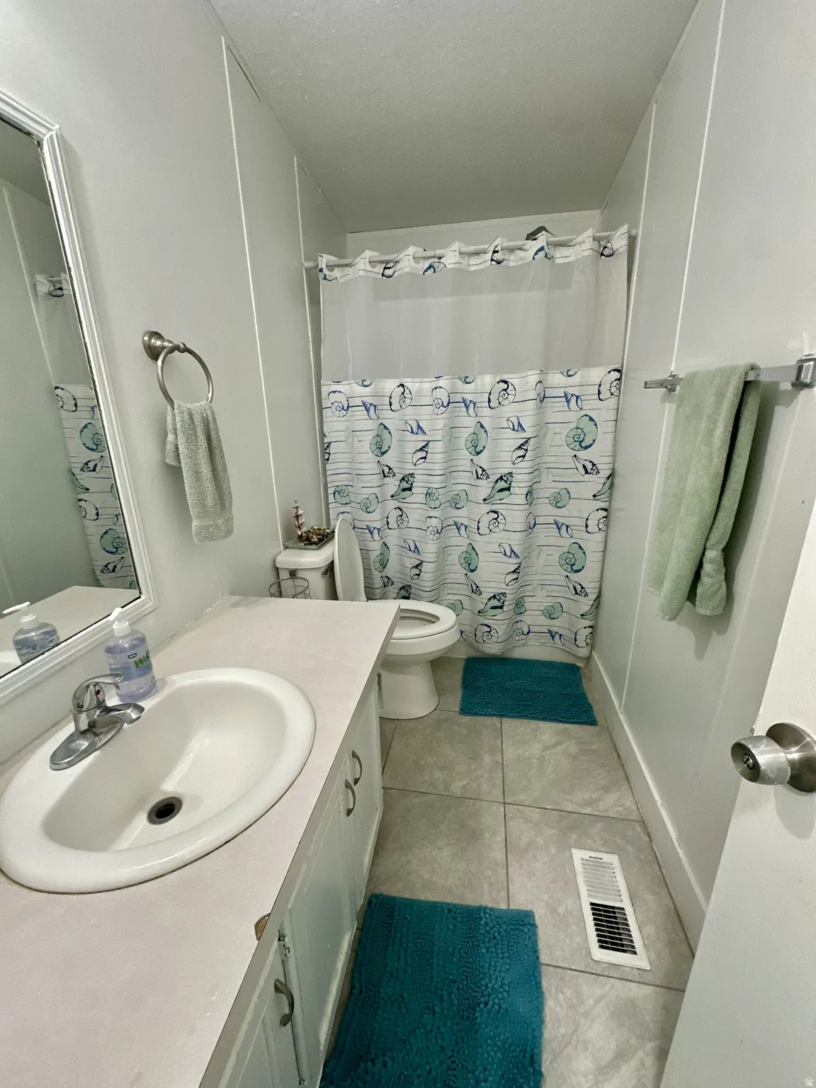 Bathroom featuring vanity, curtained shower, and light tile patterned floors