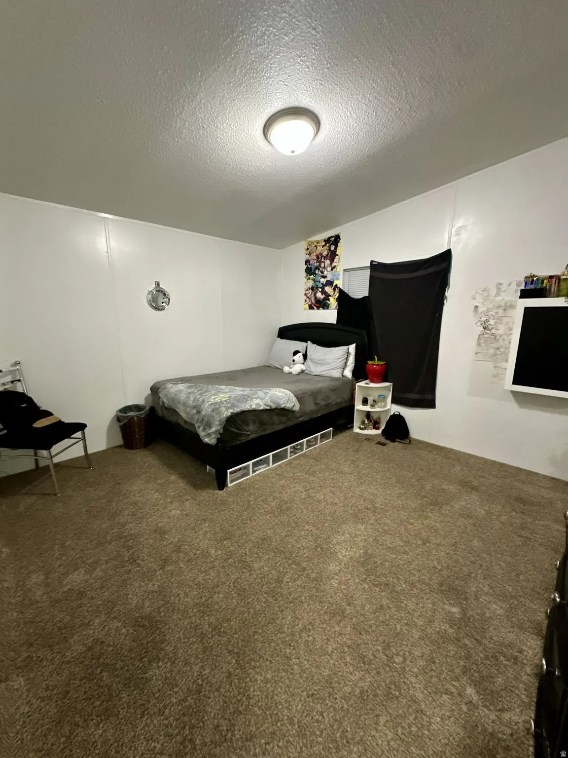 Carpeted bedroom with a textured ceiling