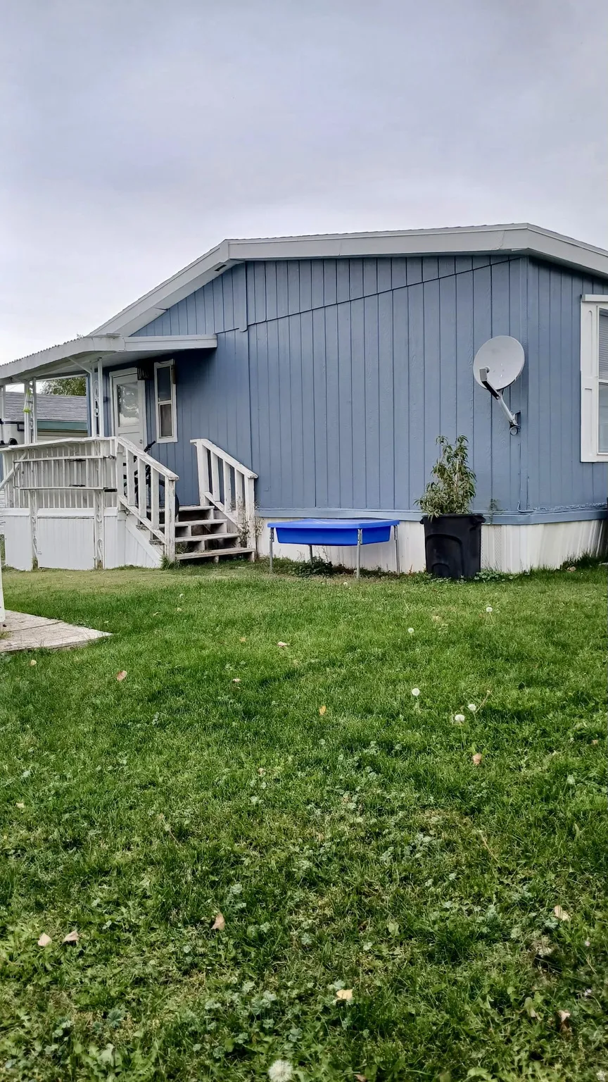 View of home's exterior with a lawn and a back deck