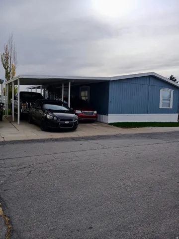 View of building exterior with an attached carport and driveway