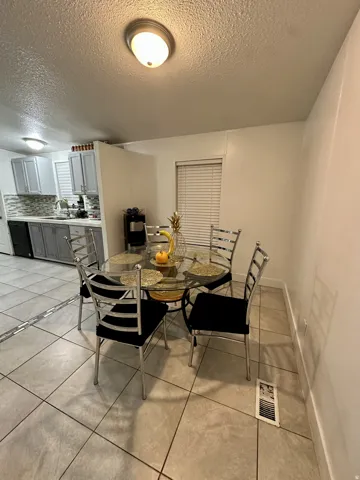 Dining space featuring light tile patterned floors and a textured ceiling