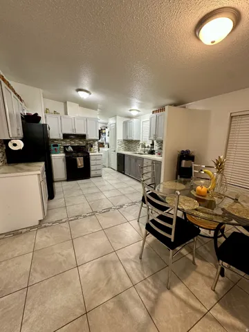 Dining space with light tile patterned floors and a textured ceiling