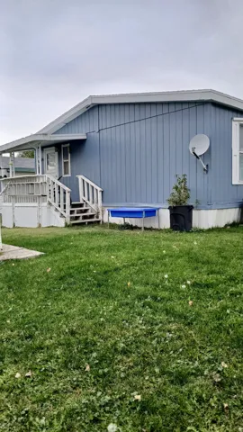 View of home's exterior with a lawn and a back deck