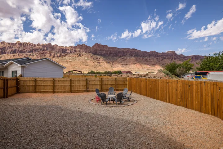 Fenced backyard with a patio area, a fire pit, and a mountain view