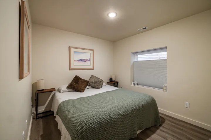 Bedroom featuring baseboards and dark wood-type flooring