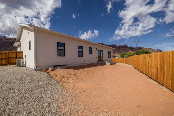 Rear view of house featuring a fenced backyard, a mountain view, a patio area, and stucco siding