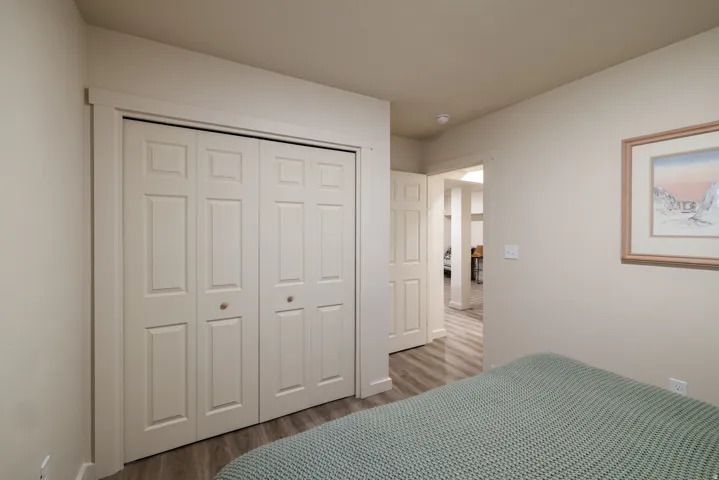 Bedroom with wood finished floors and a closet