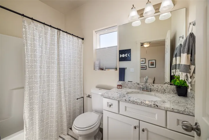 Full bathroom featuring vanity, shower / tub combo, and ceiling fan