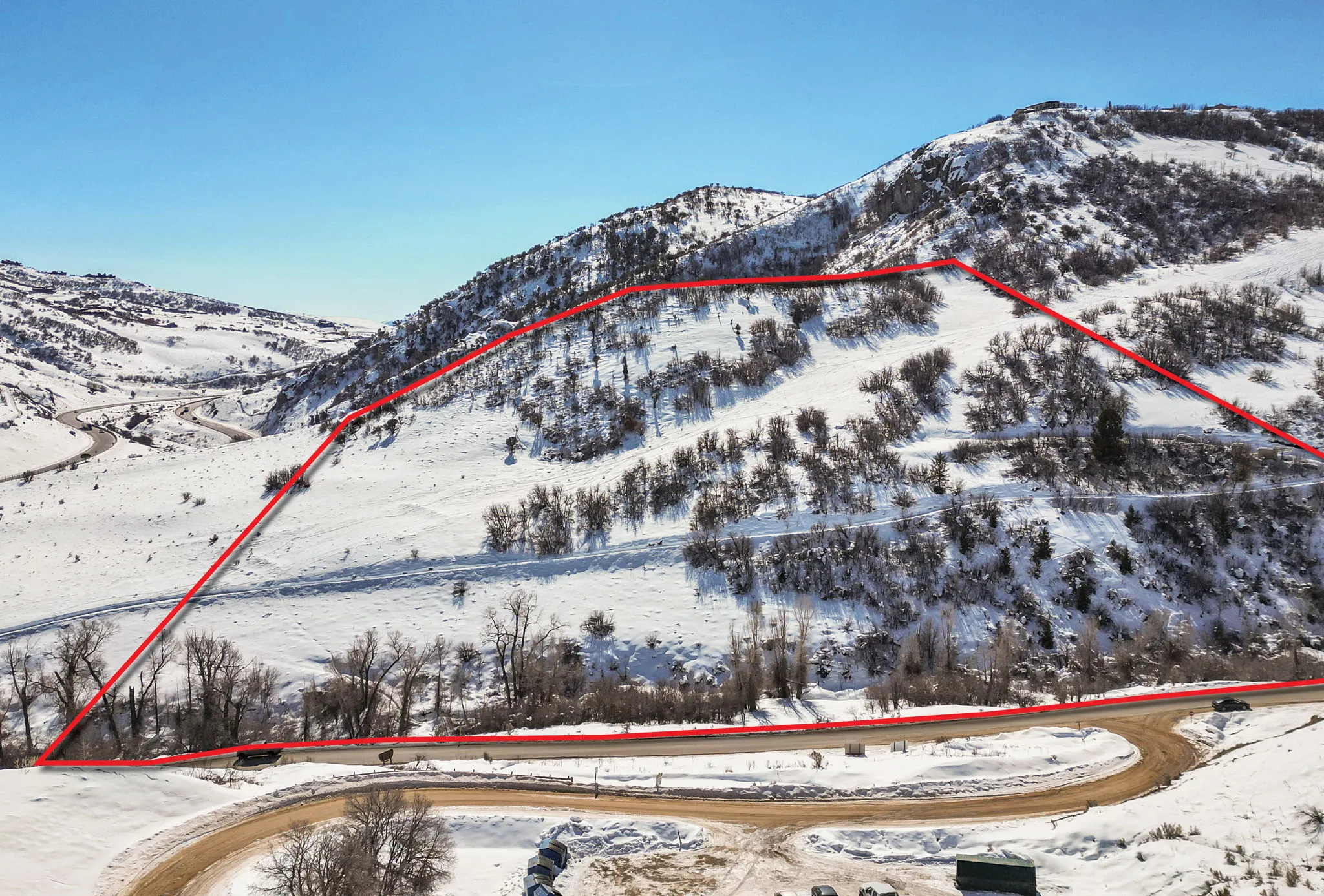 Snowy aerial view with a mountain view and property boundaries highlighted
