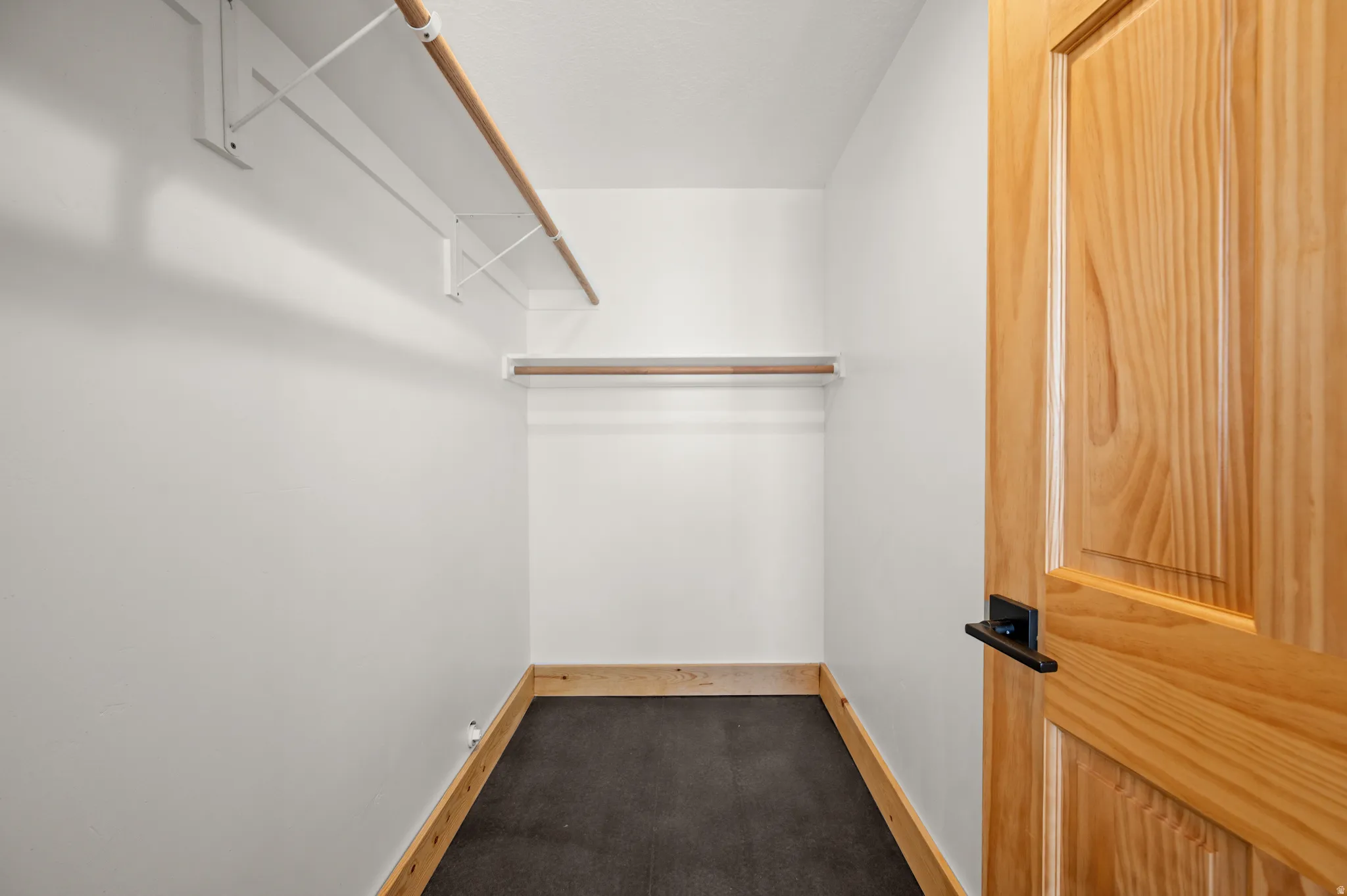 Walk in closet featuring dark carpet
