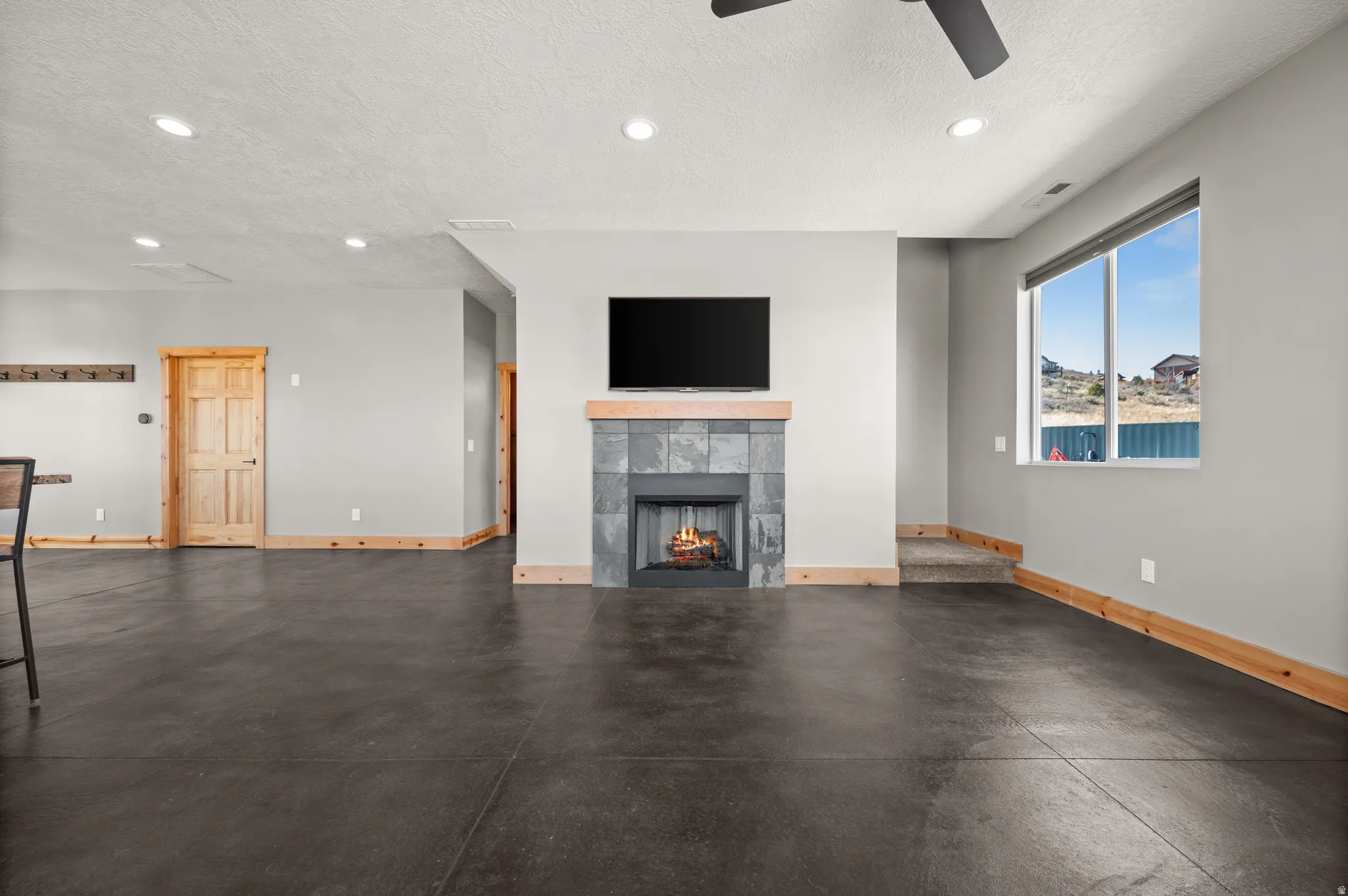 Unfurnished living room with a textured ceiling, a tile fireplace, and recessed lighting