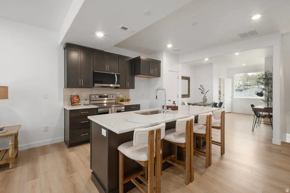 A total 'wow' kitchen-quartz countertops, stainless appliances, and a big island for charcuterie or homework. *Model