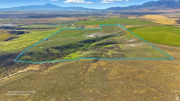 Aerial view of sparsely populated area with a mountain backdrop and property parcel outlined