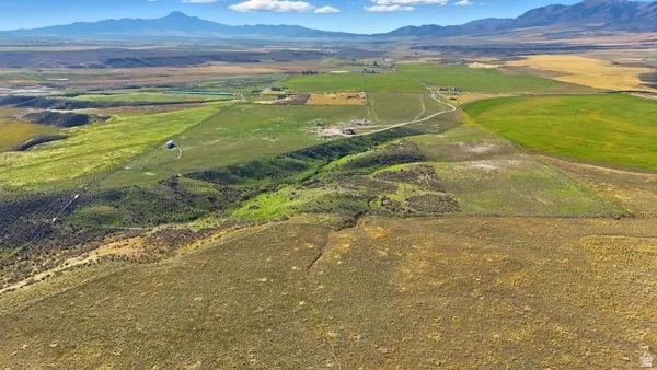 Aerial view of property and surrounding area with a mountainous background and rural landscape