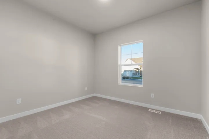 Carpeted spare room with baseboards