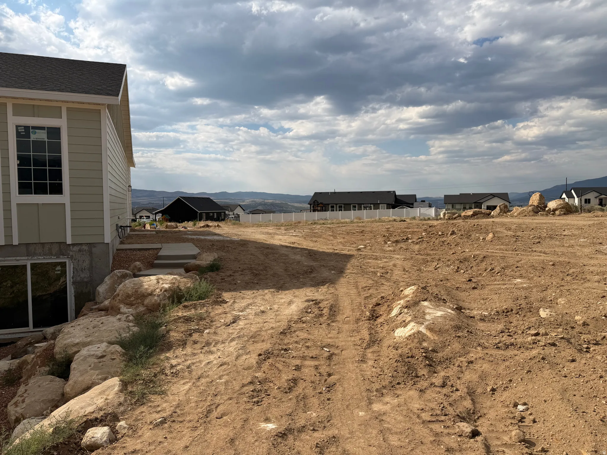 Graded lot featuring a partially constructed residence with light green siding and white trim