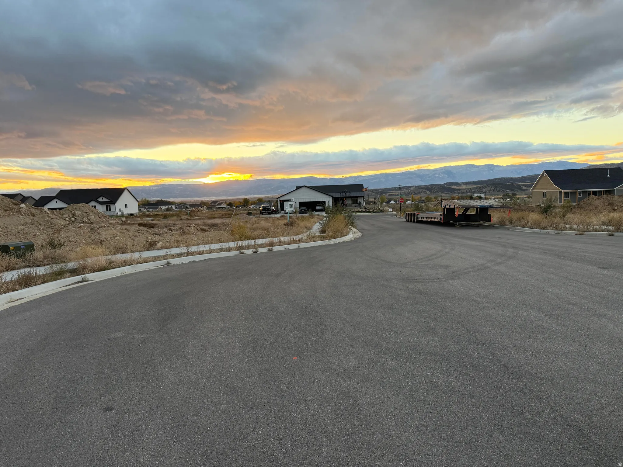 View of asphalt street featuring curbs and a mountain view