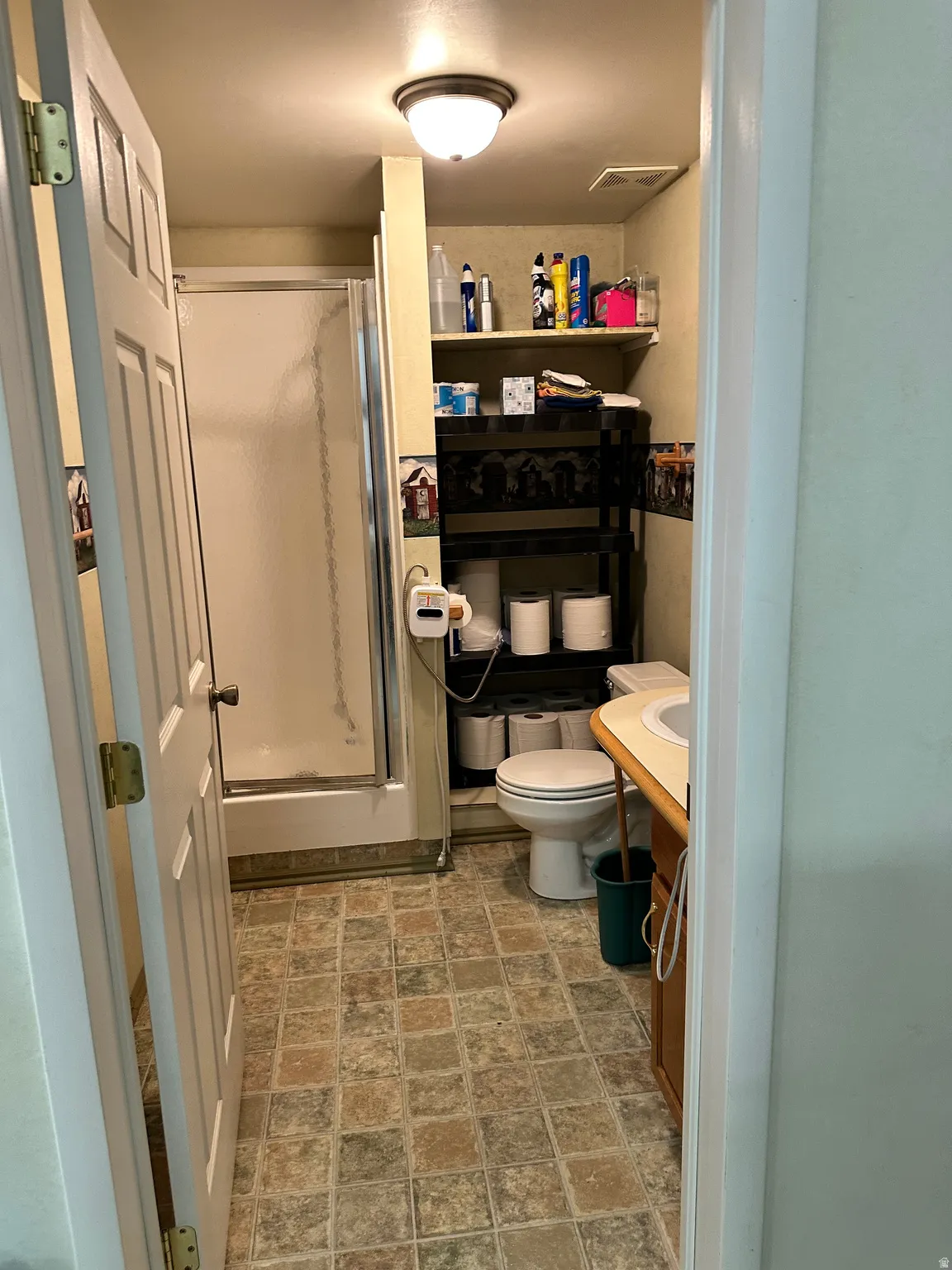 Bathroom featuring a shower stall, stone finish flooring, and vanity