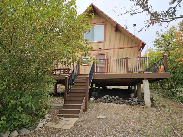 Back of house with a wooden deck, stairs, and a carport