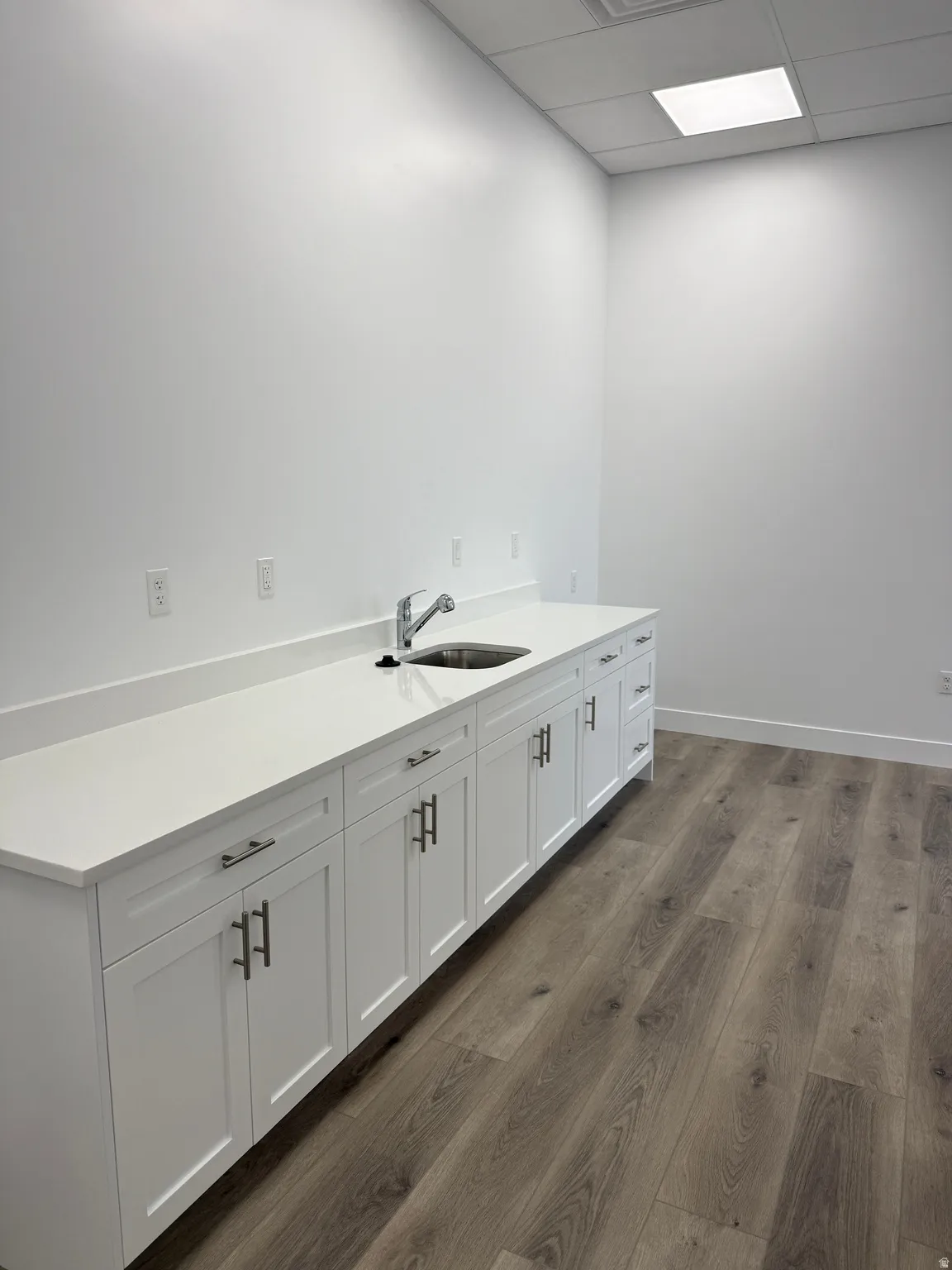 Laundry area featuring a paneled ceiling and dark wood finished floors