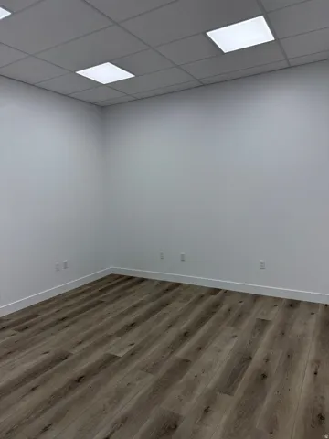 Empty room with wood finished floors and a drop ceiling