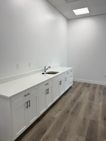 Laundry area featuring a paneled ceiling and dark wood finished floors