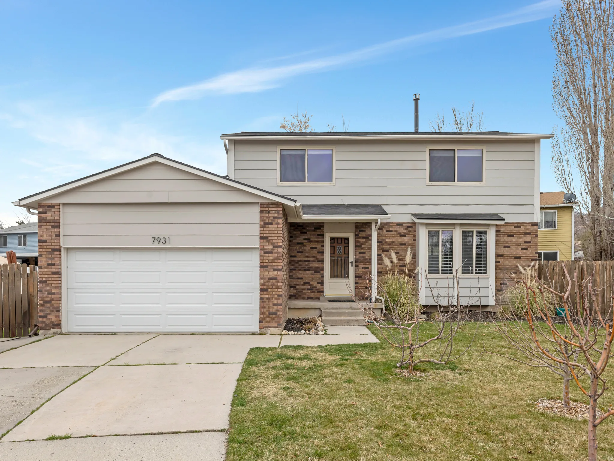 Traditional-style home with brick siding, driveway, and a garage